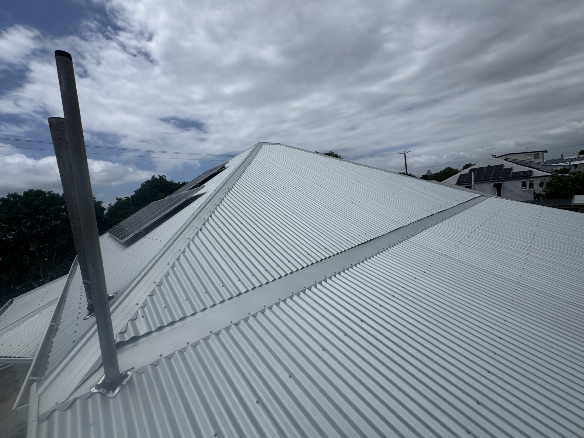 Crisp metal roof installation by ELEV8 under cloudy skies